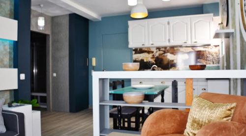 a kitchen with blue walls and a table and a chair at Porto Santo Apartment in Porto Santo