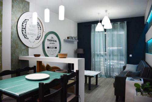a dining room with a green table and chairs at Porto Santo Apartment in Porto Santo