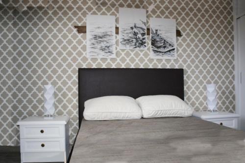 a bedroom with a bed and a wall with pictures at Porto Santo Apartment in Porto Santo