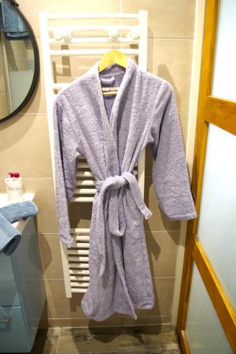 - un peignoir suspendu à un portant dans la salle de bains dans l'établissement Le Poissonnière, à Paris