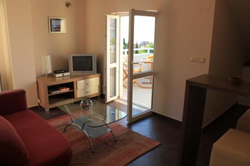察夫塔特的住宿－Apartments Marlais，客厅配有红色沙发和电视