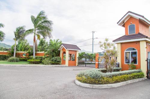 オーチョ・リオスにあるLa Casa De Playa Ocho Rios Villaの駐車場の門付き小さなオレンジ色の建物