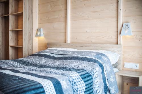a bedroom with a bed with a blue and white blanket at Stachelisko - domki i pokoje in Chochołów