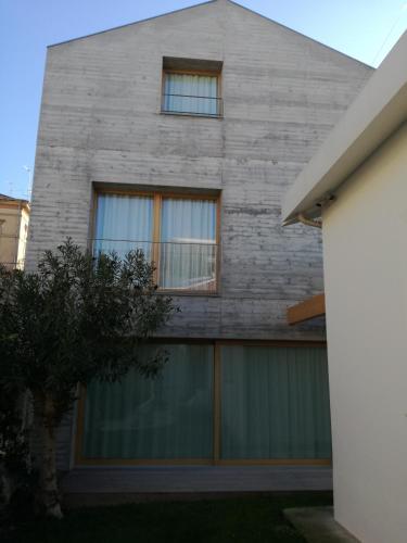 a gray brick house with a green garage at La casa di Mario tra le case in Ortona