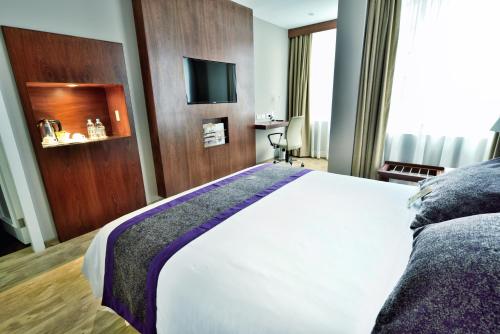 a hotel room with a bed and a tv at Mercure Alameda Quito in Quito