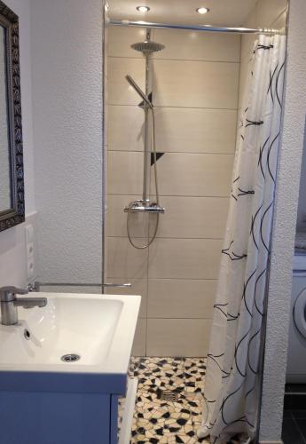 a bathroom with a sink and a shower curtain at Ferienhaus Moselblick mit kostenfreien ÖPNV-Ticket in Ürzig