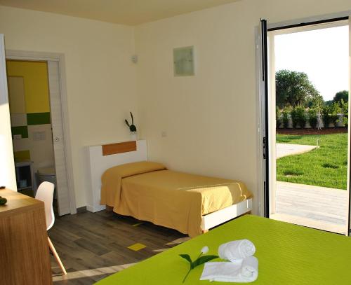 a bedroom with two beds and a sliding glass door at La Giara in Marina di Modica