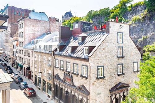 an old brick building on a city street with cars at Les Lofts St-Pierre - Par Les Lofts Vieux-Québec in Quebec City