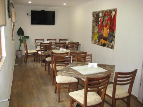 a dining room with tables and chairs and a tv at Къща за гости Романс in Yagodina
