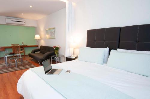 a hotel room with a bed with a laptop on it at Lombardo Suites in Mexico City