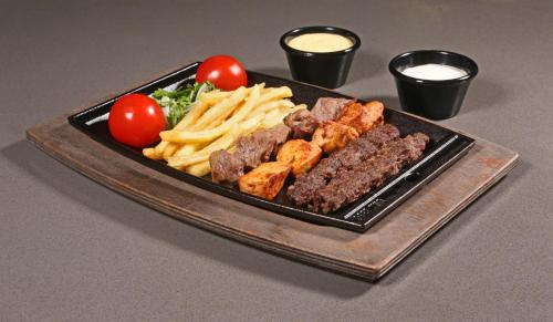 a plate of food with meat and french fries at Urban Central Suites - Beirut in Beirut