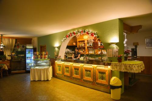a woman standing at the counter of a restaurant at Camping Catinaccio Rosengarten in Pozza di Fassa