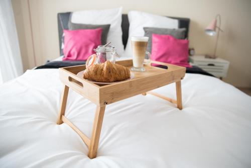 a tray with bread and a cup of coffee on a bed at Apartament Soft 11 in Biała Podlaska