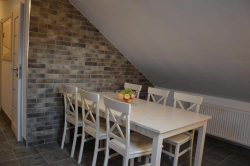 a dining room with a brick wall and a table and chairs at Apartmány Charlie in Bešeňová
