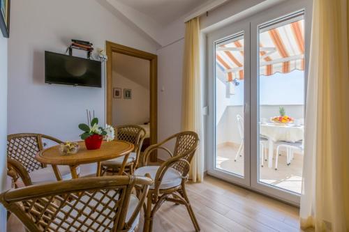 a dining room with a table and chairs and a balcony at Two-Bedroom Apartment in Crikvenica XXXIV in Dramalj