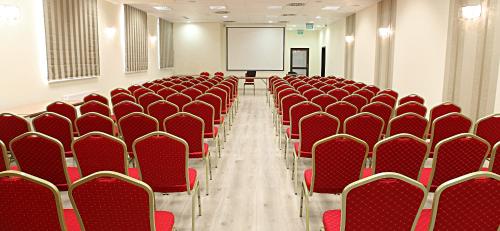 pusty pokój z czerwonymi krzesłami i ekranem w obiekcie Hotel Forum Fitness Spa & Wellness w mieście Lublin