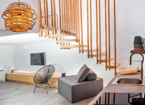 a living room with wooden stairs and a chair at Santorini Soul Villas in Pirgos