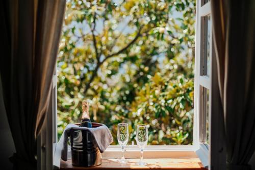 una ventana abierta con dos copas de vino y una jarra en Stanica B&B en Herceg-Novi