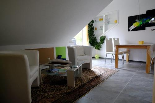 ein Wohnzimmer mit weißen Möbeln und einem Tisch in der Unterkunft Ferienwohnung Henry im schönen Allgäu in Westendorf