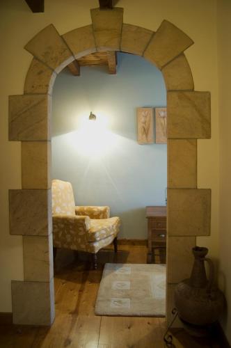 an archway in a living room with a chair and a table at Posada Rural Peñasagra in Quintanilla