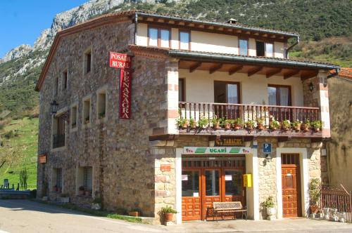 a building with a balcony on the side of it at Posada Rural Peñasagra in Quintanilla
