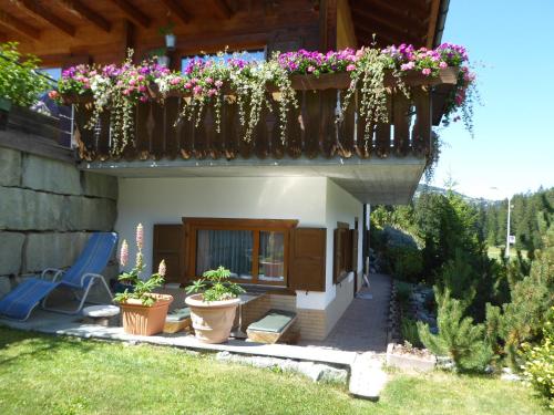 a house with a balcony with potted plants on it at Apartment Fadail 2B in Lenzerheide