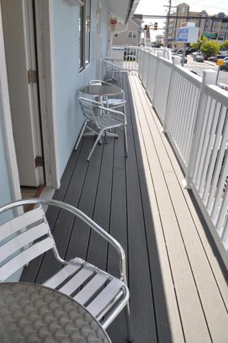 a row of chairs and tables on a balcony at Coastal Inn - Ocean City in Ocean City