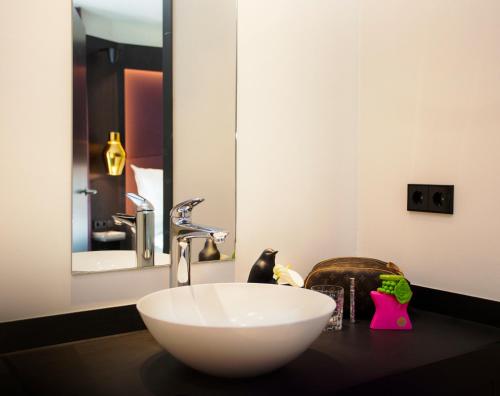 a bathroom with a white sink and a mirror at ONNO Boutique Hotel & Apartments in Rendsburg