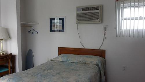 a bedroom with a bed and a air conditioner at Tide Winds Motel in Wildwood