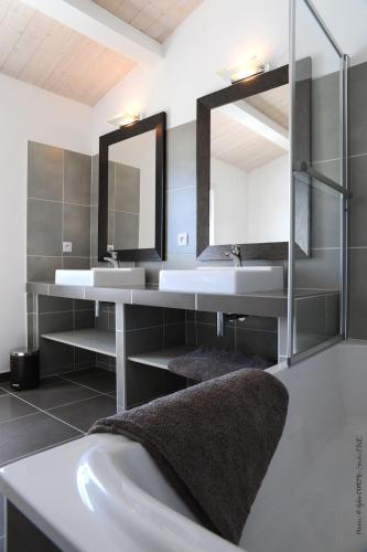 une salle de bain avec deux lavabos et un miroir dans l'établissement villas des phares, à La Flotte