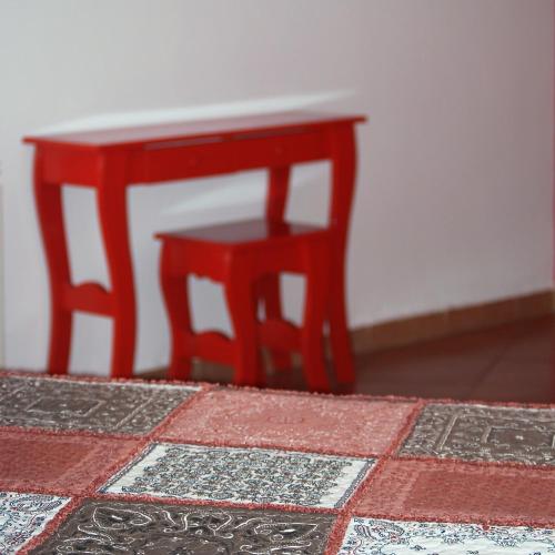 a red stool next to a red table and chair at IRUPÉ APART HOTEL in Federación