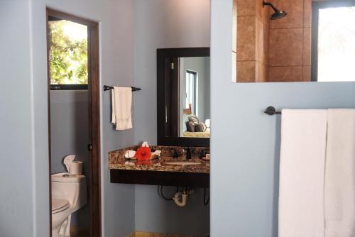 uma casa de banho com um lavatório e um espelho em Cerritos Beach Inn em El Pescadero