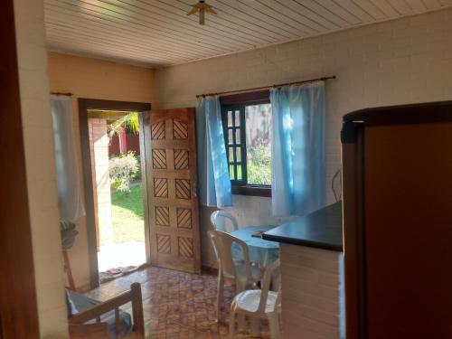 Una habitación con cocina con mesa y sillas. en Chalés Ki Bakana, en Ubatuba