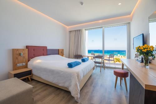 a hotel room with a bed and a view of the ocean at Protaras Plaza Hotel in Protaras