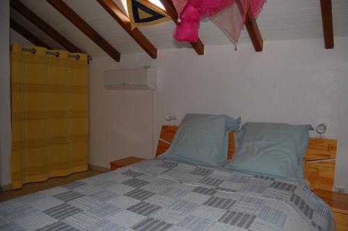 1 dormitorio con 1 cama con almohadas azules en Gîtes la Marlyse, en Bouillante