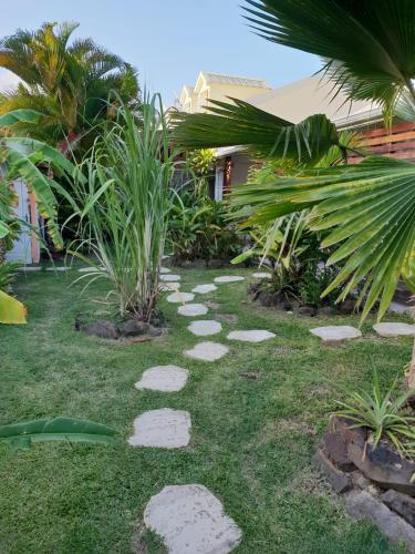 a garden with stepping stones on the grass at Orcéa & Spa Séjours Ecofriendly in Sainte-Anne