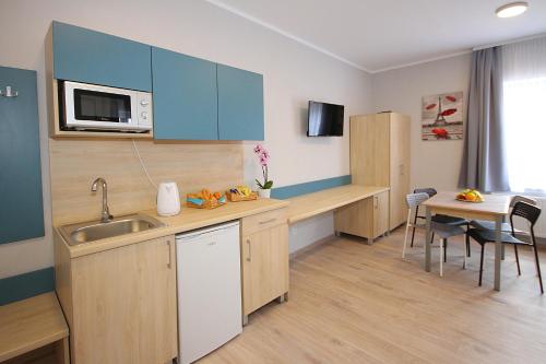 a small kitchen with a sink and a microwave at Willa Park Apartamenty in Olsztyn