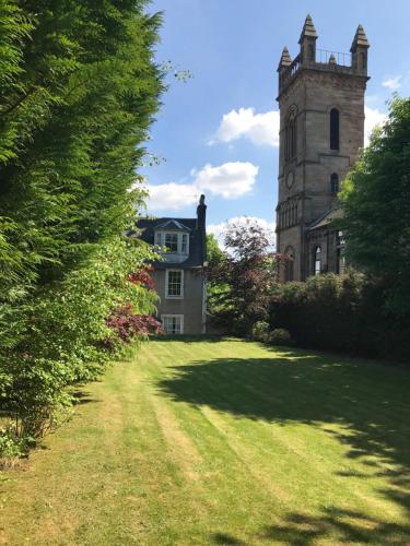 an old building with a clock tower in the middle of a yard at Ashtree House Hotel, Glasgow Airport & Paisley in Paisley