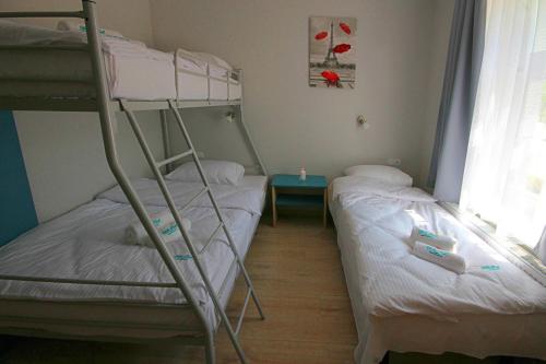 two bunk beds in a small room with a window at Willa Park Apartamenty in Olsztyn