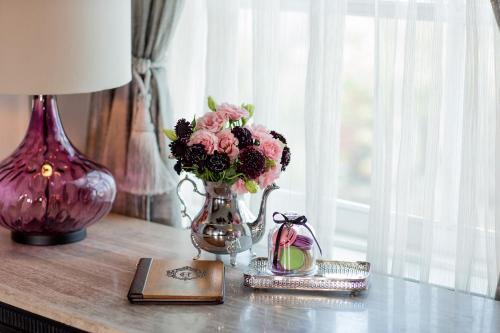 a table with a vase of flowers and a book at The Culver Hotel in Los Angeles