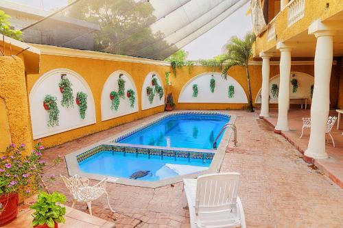 basen na patio z krzesłami i budynek w obiekcie Hotel Suites Ejecutivas w mieście Ciudad Madero