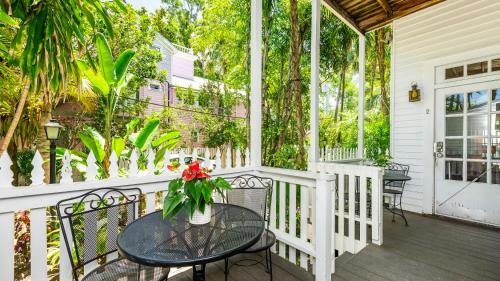 a porch with a table with a vase of flowers at Old Town Manor in Key West