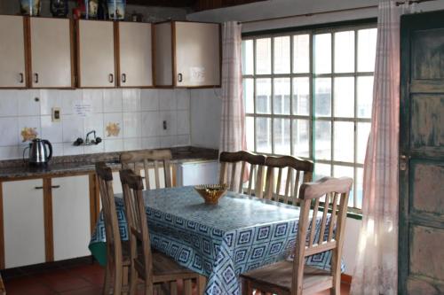 cocina con mesa, sillas, mesa y ventana en Casa de montaña, valle del sol, potrerillos, Mendoza en Mendoza