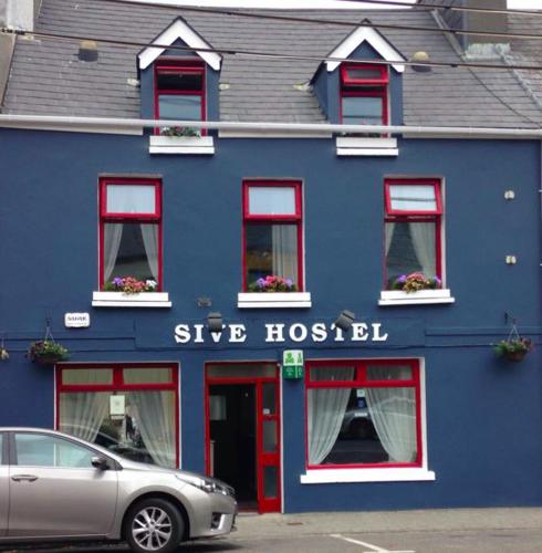 a blue building with a silver car parked in front of it at Sive Budget Accommodation in Cahersiveen