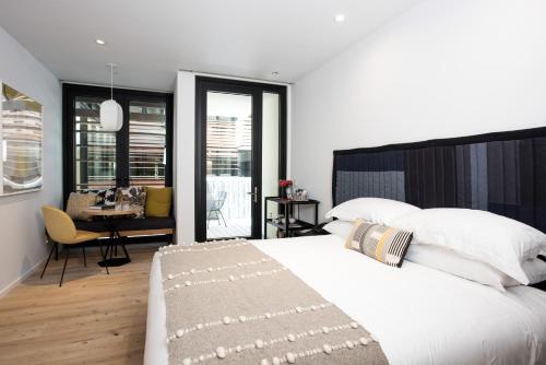 a bedroom with a large white bed and a desk at Harmon Guest House in Healdsburg