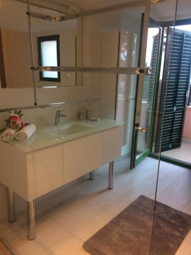 een badkamer met een wastafel en een spiegel bij Lory in Sveti Lovreč Pazenatički
