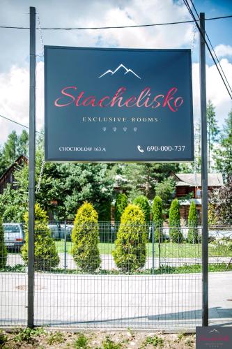 a sign for a restaurant on a fence at Stachelisko - domki i pokoje in Chochołów