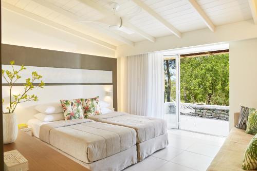 a bedroom with a bed and a large window at Makryammos in Limenas