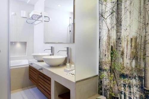 een badkamer met 2 wastafels en een douchegordijn bij Makryammos Bungalows in Limenas