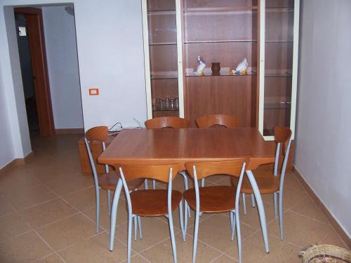 Un comedor con mesa y sillas de madera. en Villa Chiara - Vittoria, en Vittoria